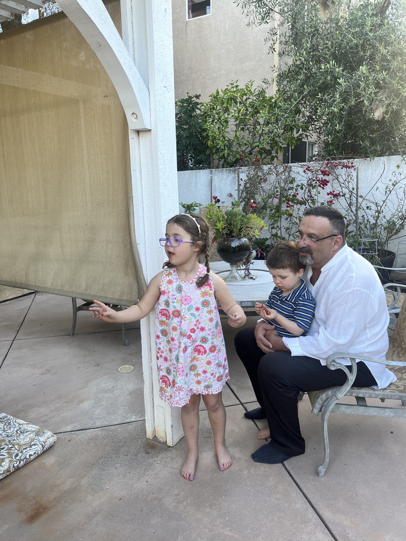 Sababa sitting with two children in the backyard