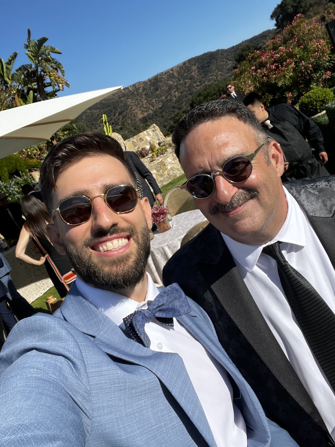 Adam and Alan wearing sunglasses together at a wedding