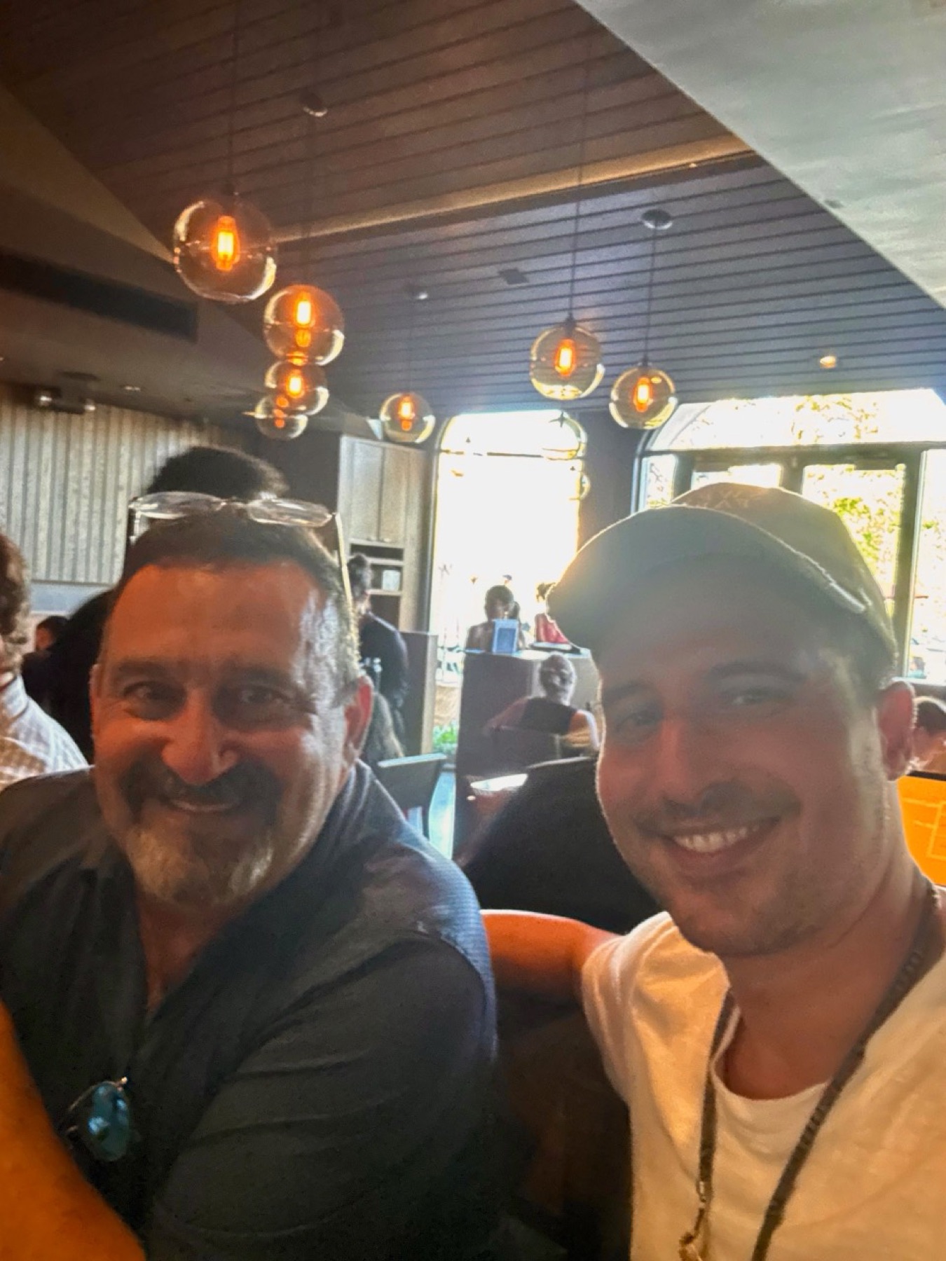 Alan smiling with family during a meal