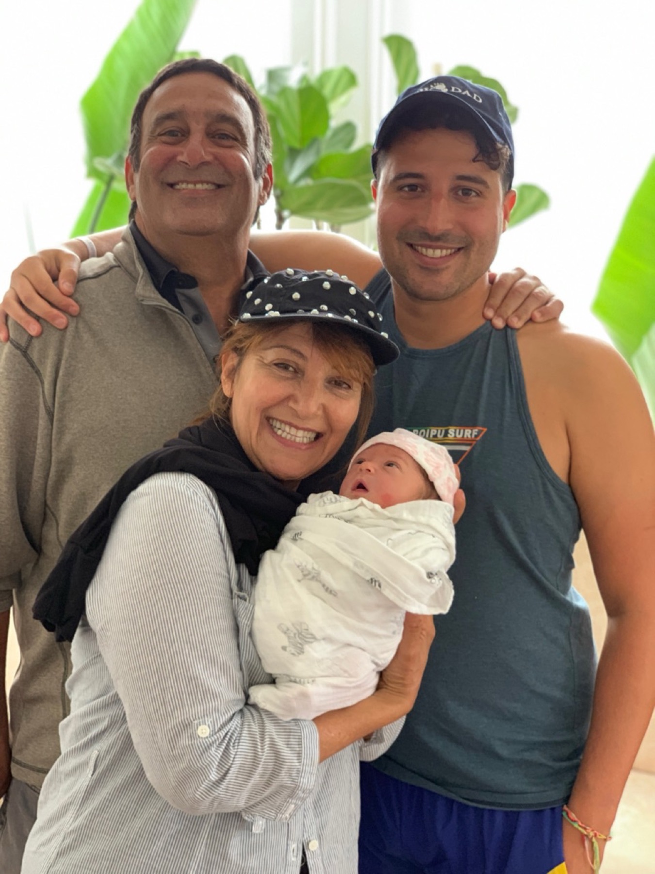 Alan and family smiling together with a newborn baby